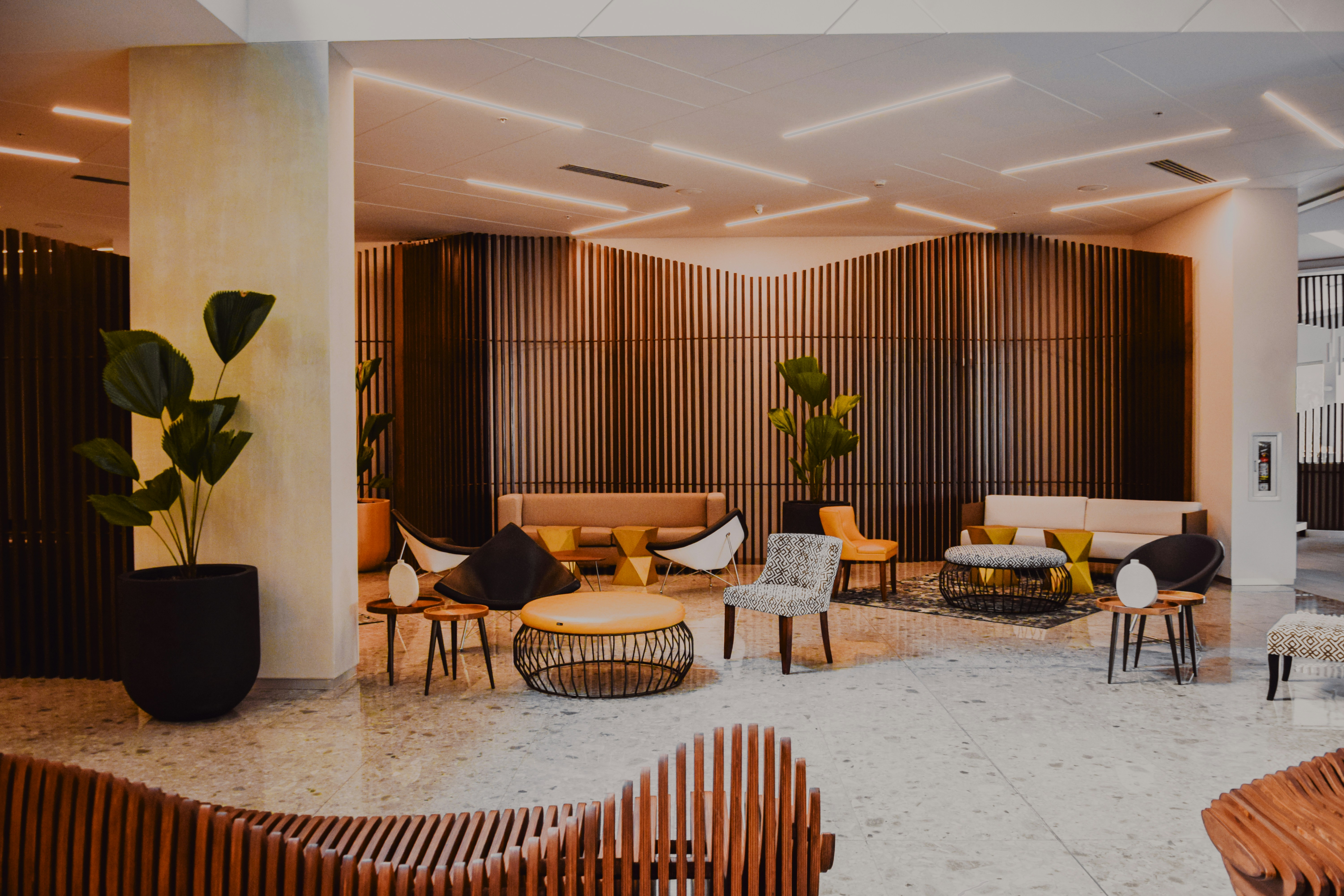 Modern hotel lobby with lounge chairs and wood-paneled walls, photographed by Frames For Your Heart
