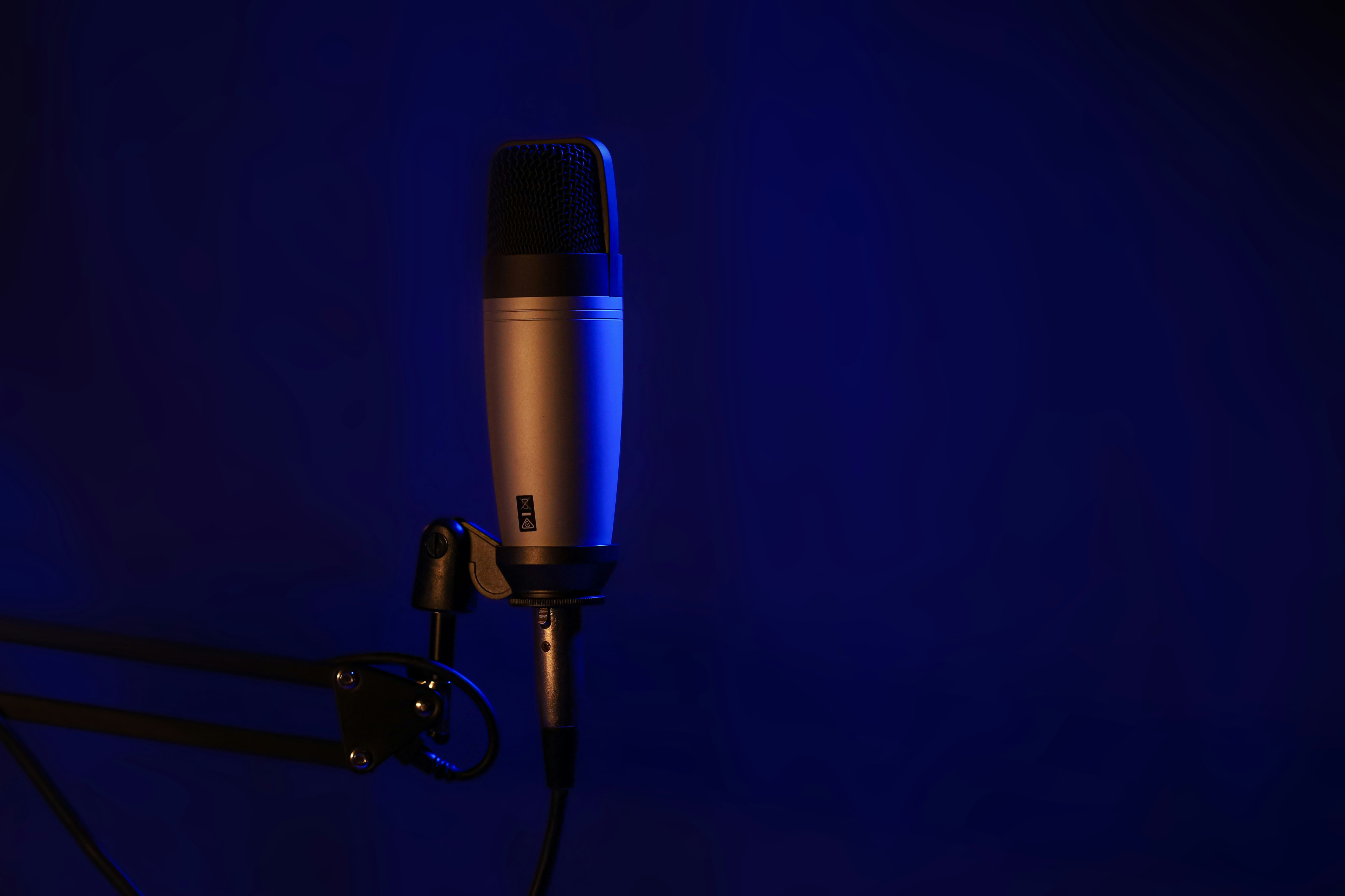 Studio microphone on a stand in a dark room, photographed by Mikey Rogers